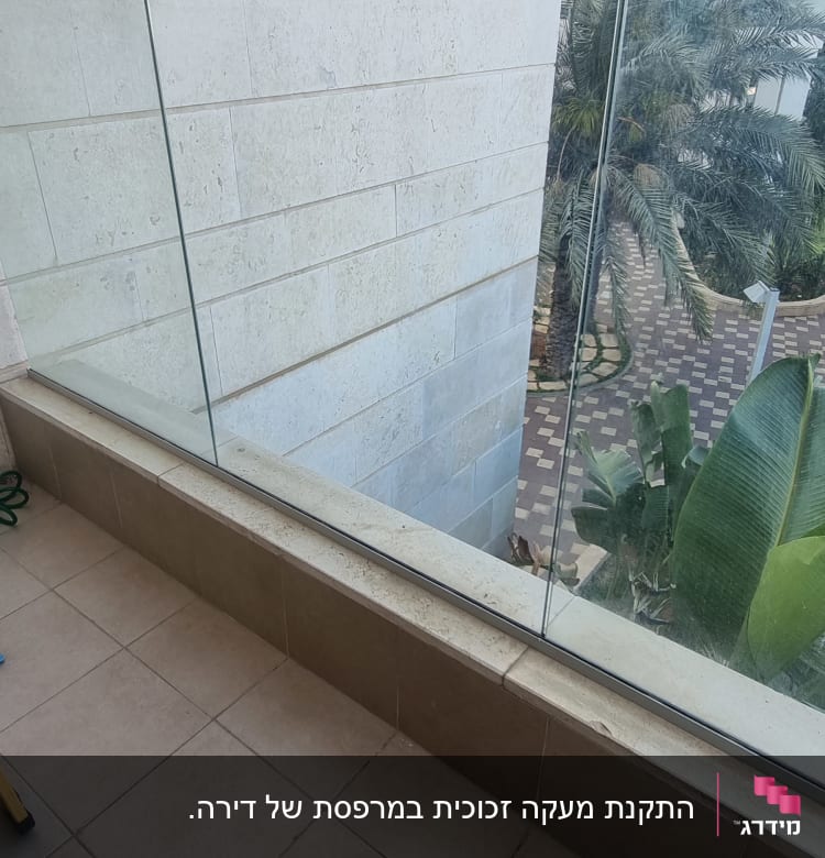 מעקה זכוכית במרפסת עם קיר אבן